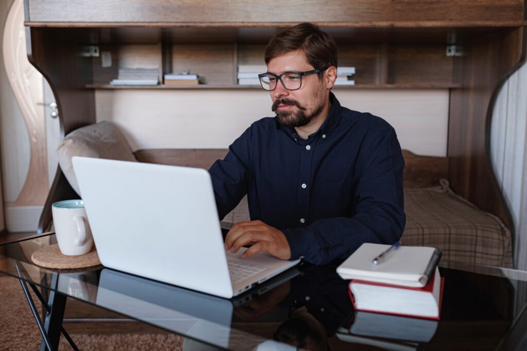 Focused man sitting at desk watching webinar video course